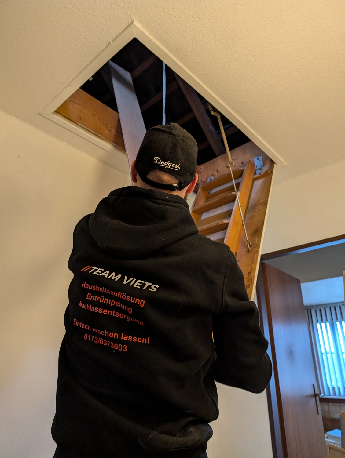Team Viets - Haushaltsauflösung - Ein Arbeiter steht auf einer Leiter, die zum Dachboden führt.
